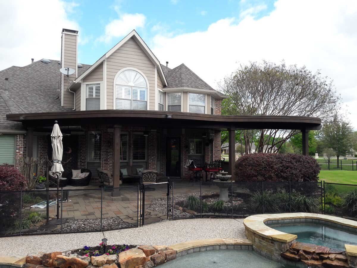 A large house with a patio and a pool in front of it.