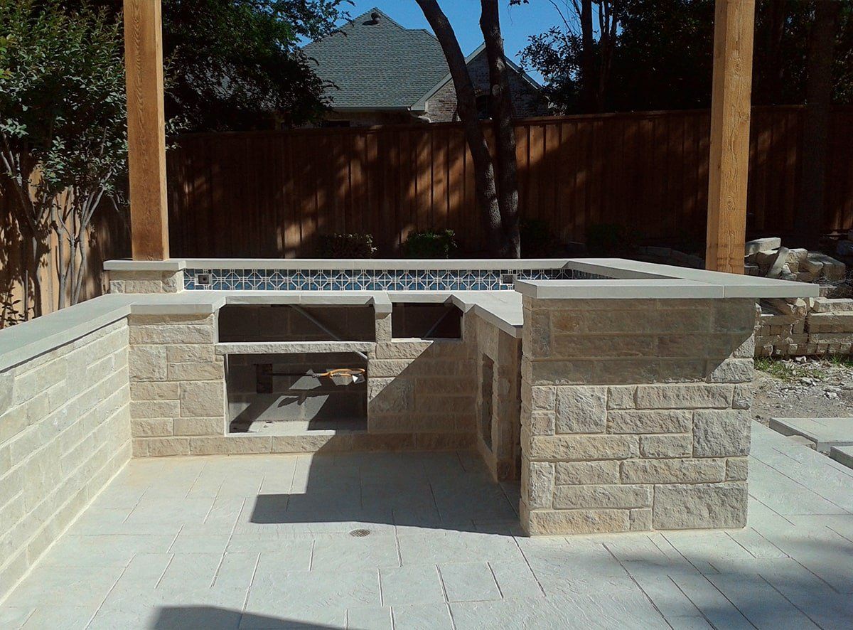 A brick patio with a wooden fence in the background