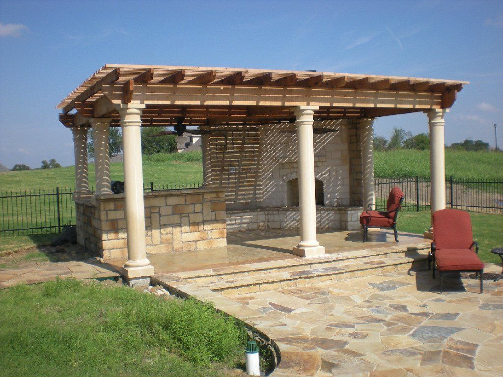 A patio with a pergola and chairs in the backyard