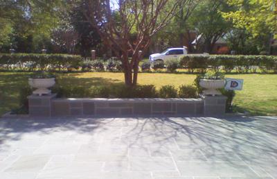 A white truck is parked in a driveway next to a tree.