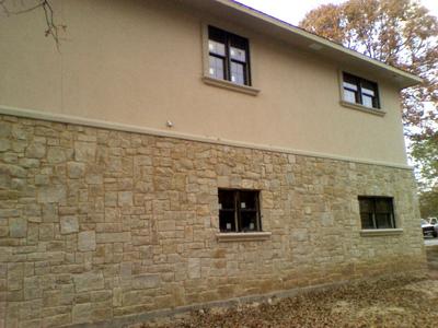 A house with a stone facade and two windows