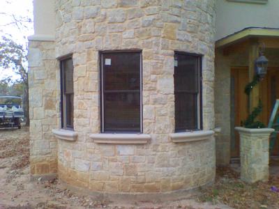 A brick building with three windows on the side of it.