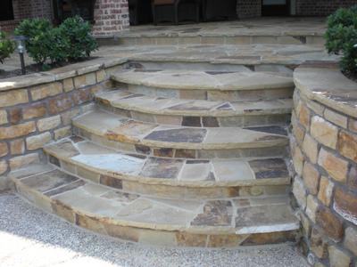 A set of stone steps leading up to a brick wall.