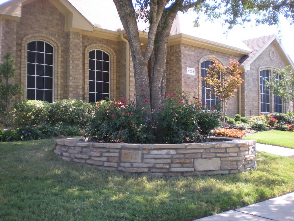 A brick house with a stone wall in front of it