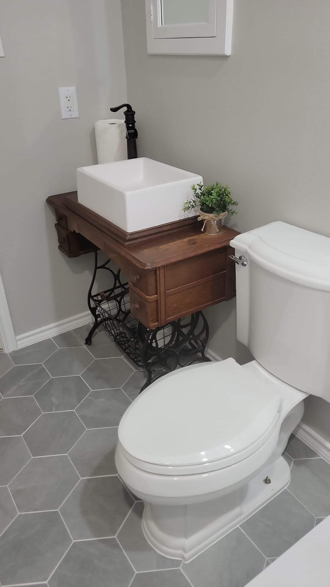 A bathroom with a toilet , sink , and mirror.