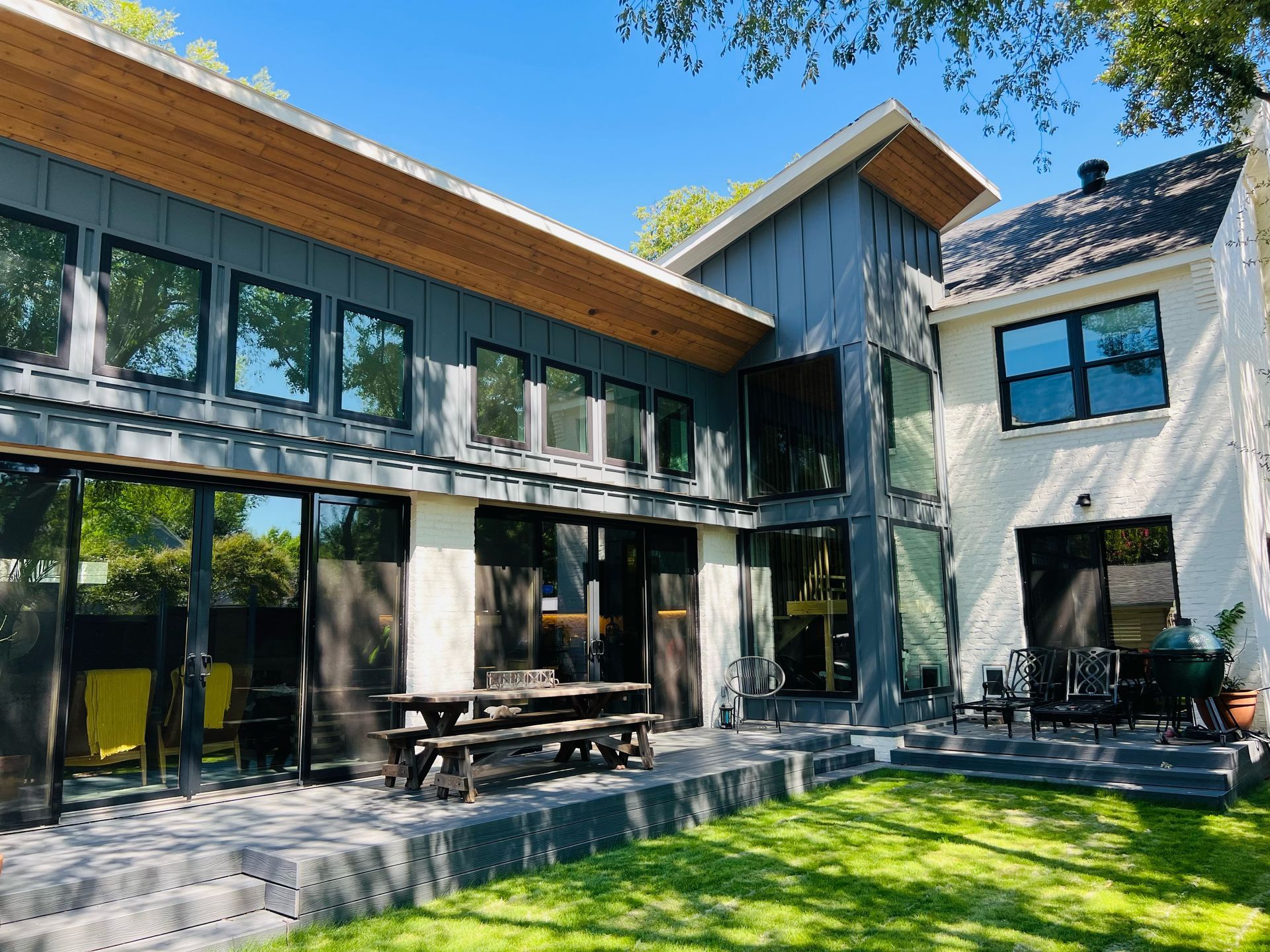 A large house with a lot of windows and a large lawn in front of it.