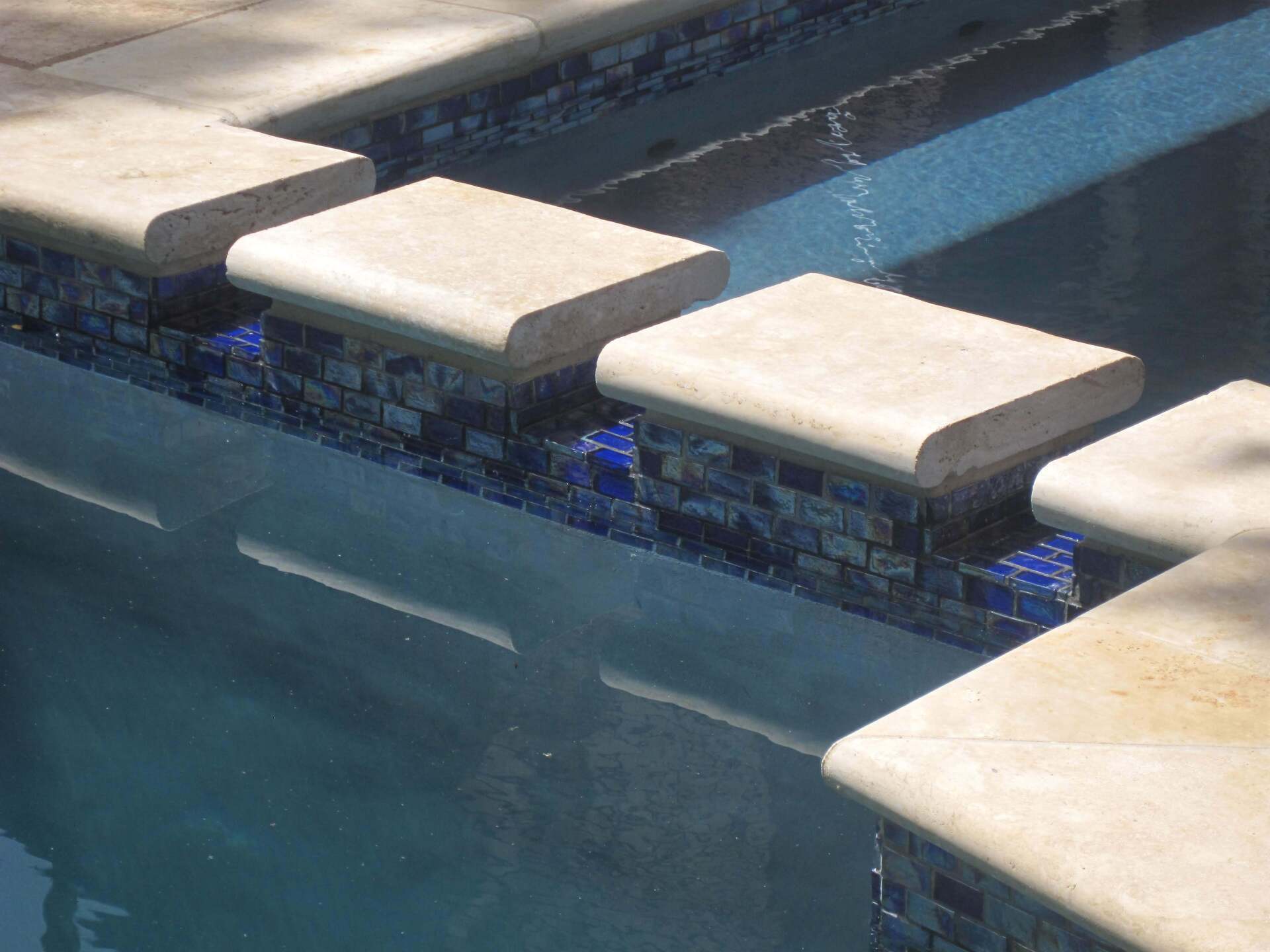 A swimming pool with a row of steps leading up to it.