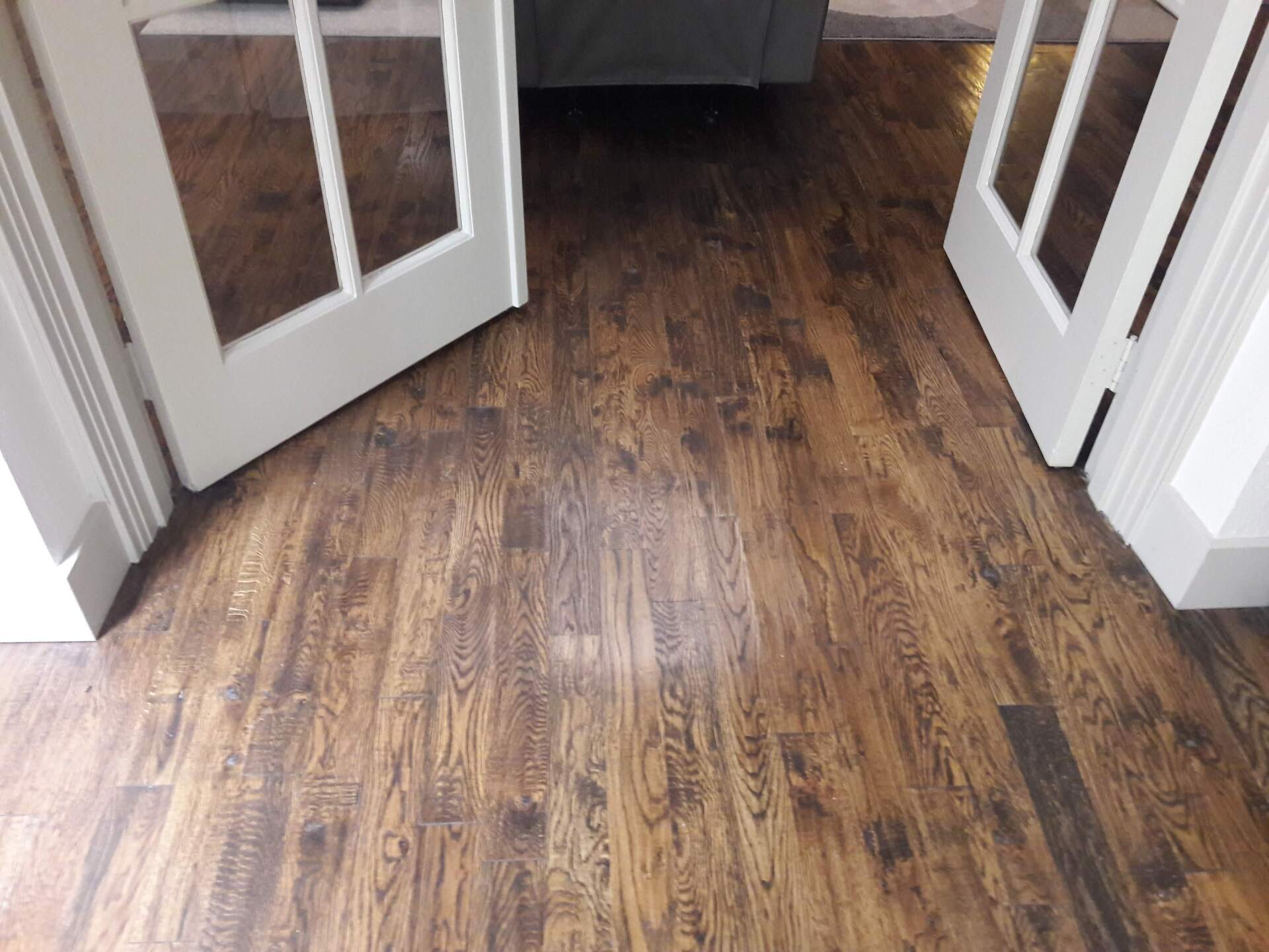 A hallway with a wooden floor and white doors