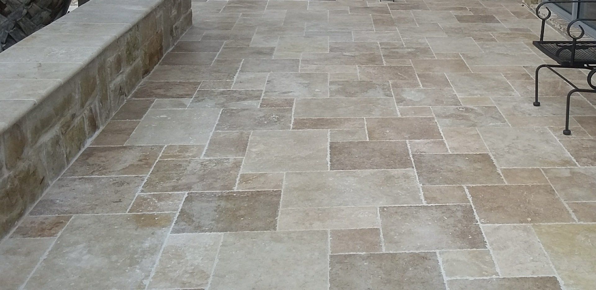 A tiled floor with a bench and chairs on it.