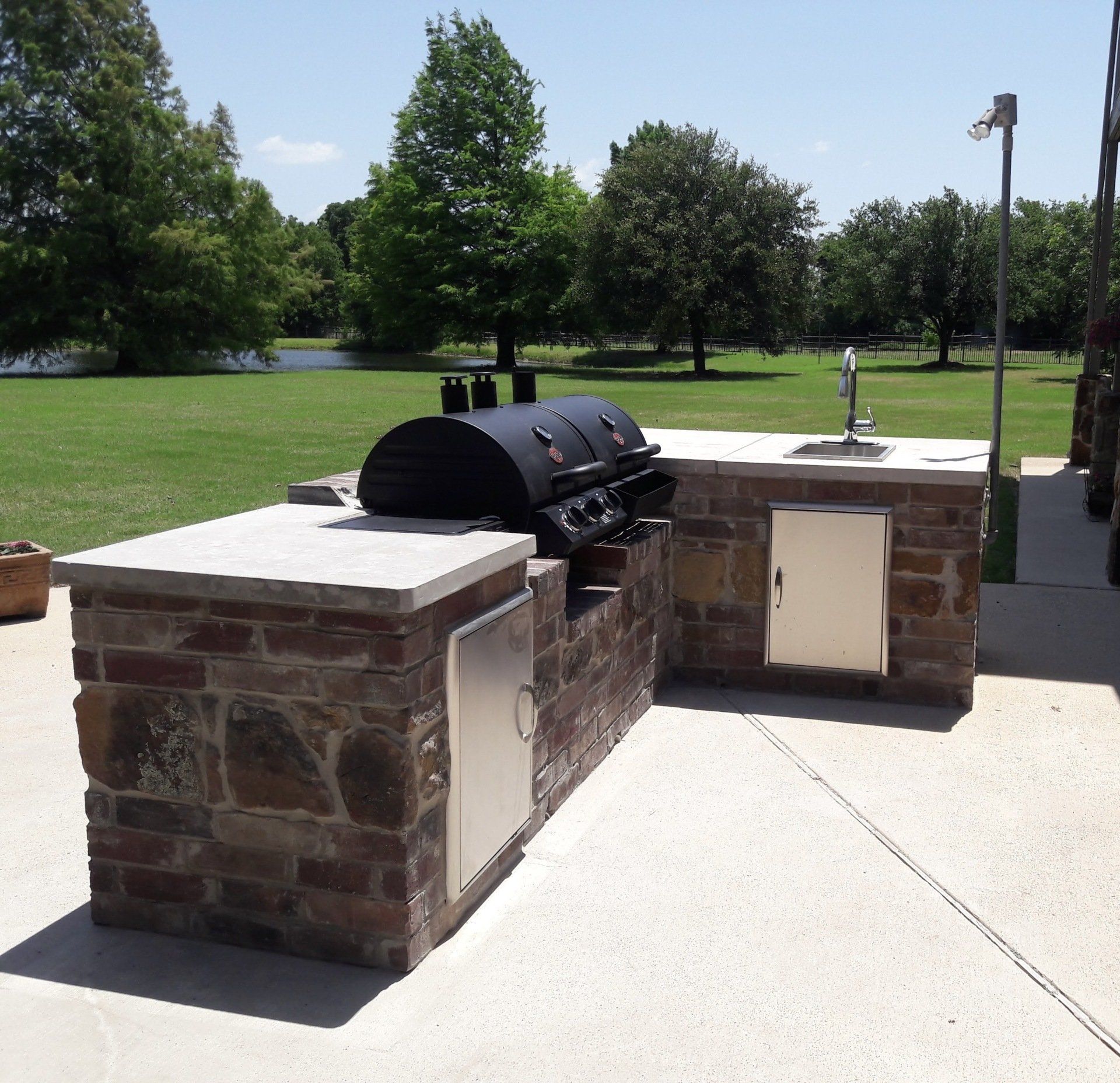 An outdoor kitchen with a grill and a sink