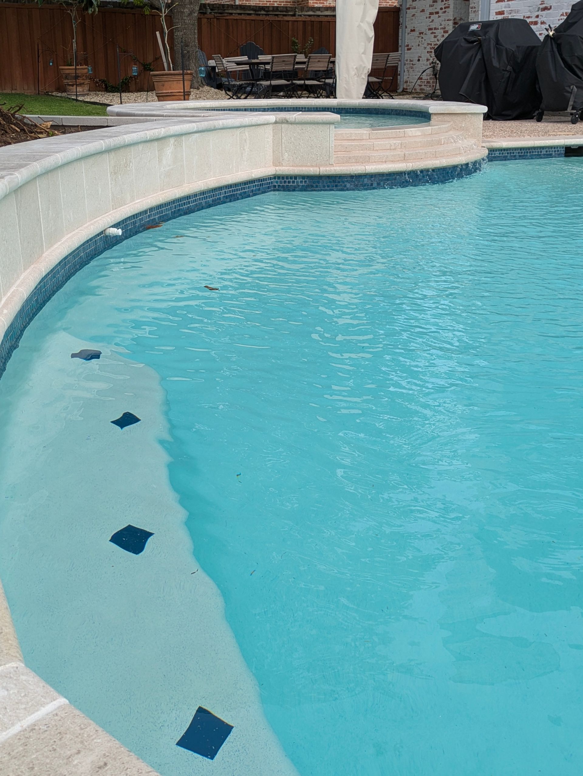 Swimming pool with light blue water and a tiled edge.