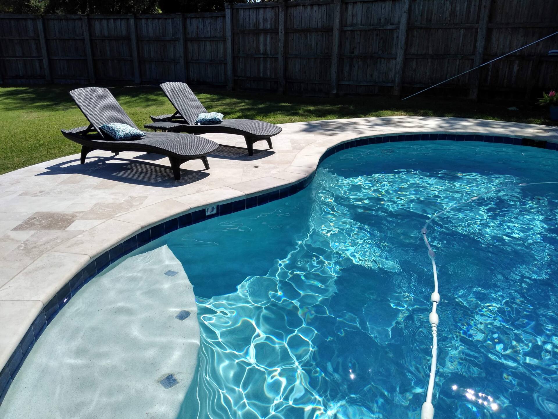 Three lounge chairs are sitting next to a swimming pool