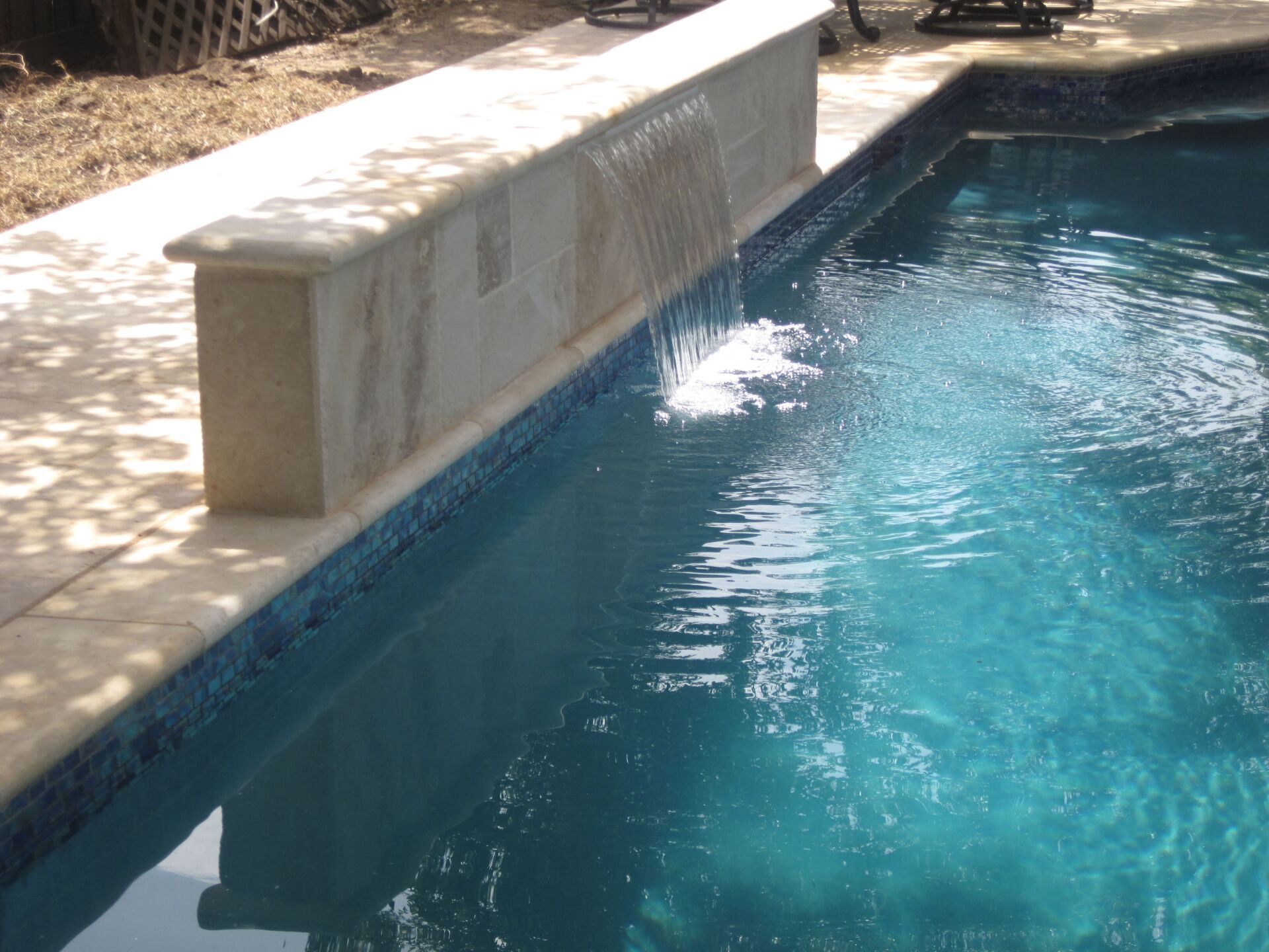 A swimming pool with a waterfall on the side of it