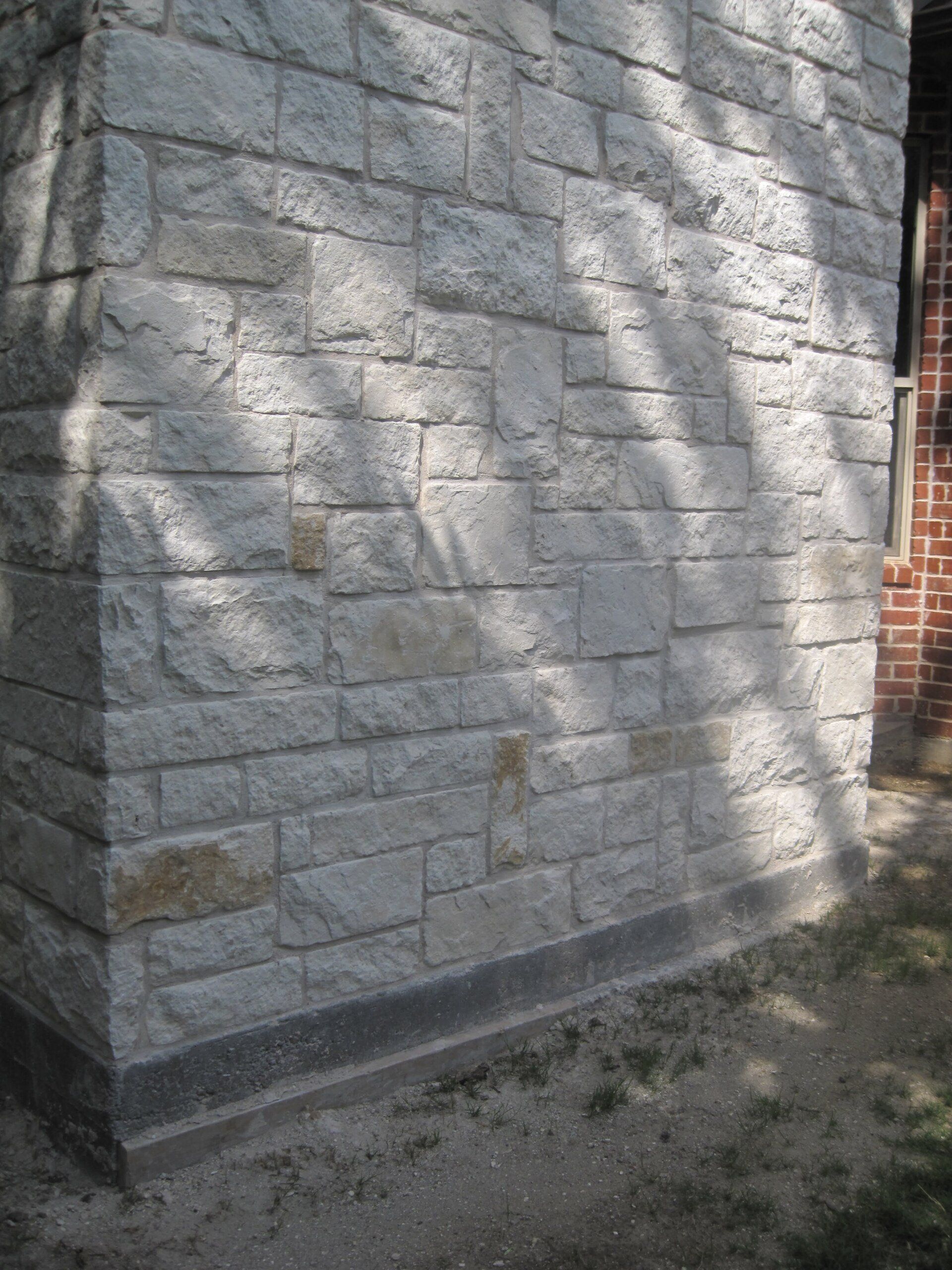 A brick wall with a tree shadow on it