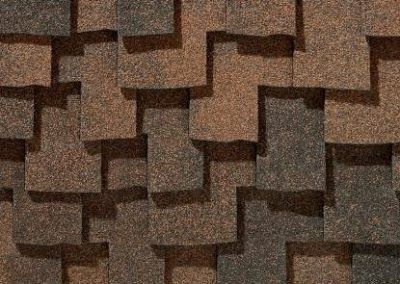 Close-up of overlapping brown and dark gray asphalt roofing shingles.