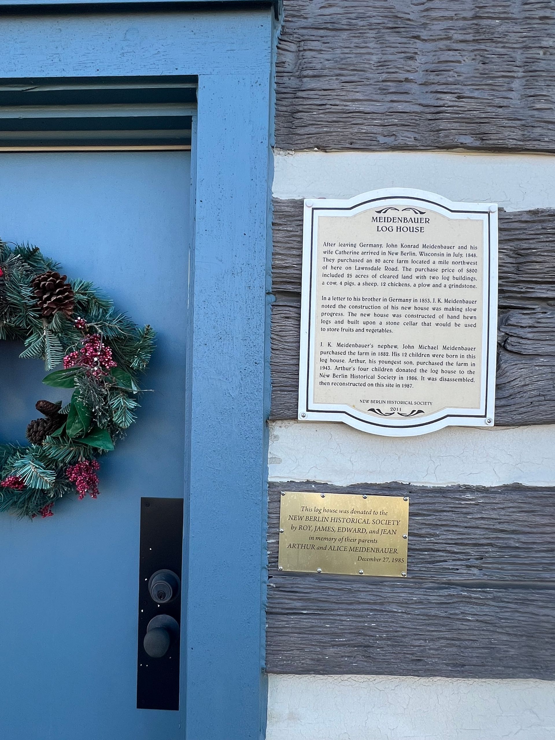 Person paints a textured wall with a blue paint roller.