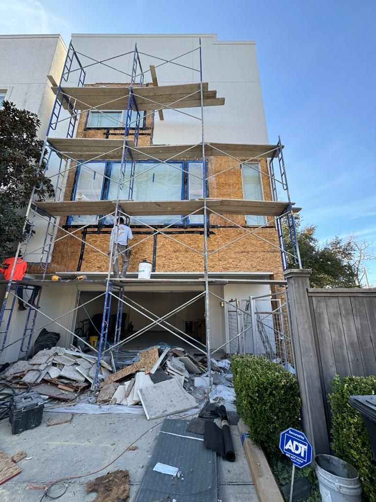 A building is being remodeled with scaffolding and a sign in front of it.