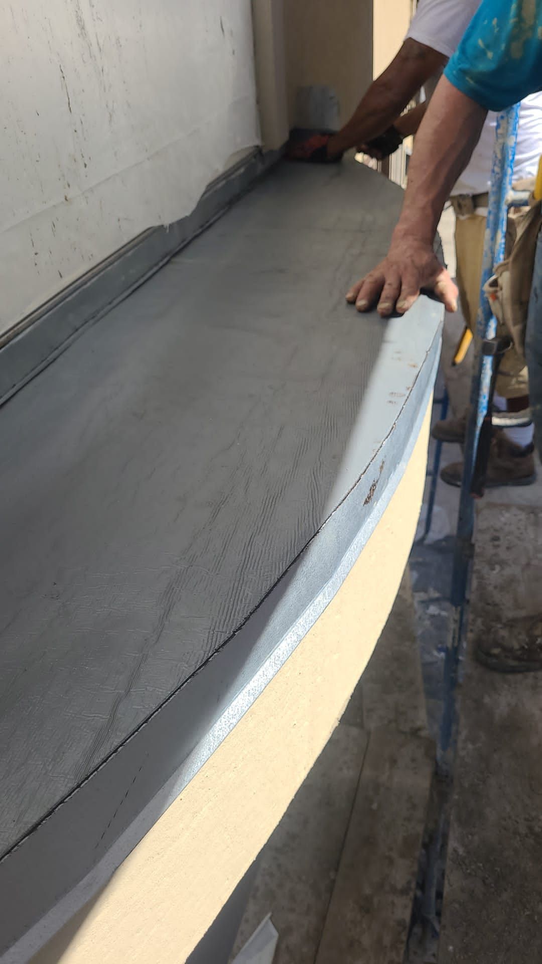 A man is standing on a ladder holding a piece of concrete.
