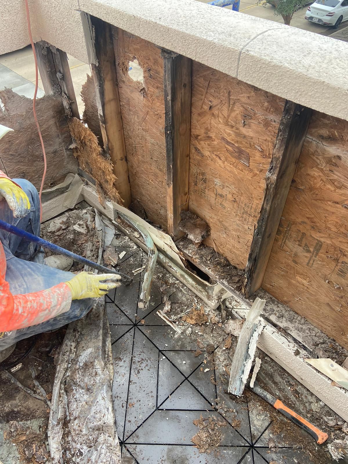 A man is cleaning a hole in a wall with a broom.