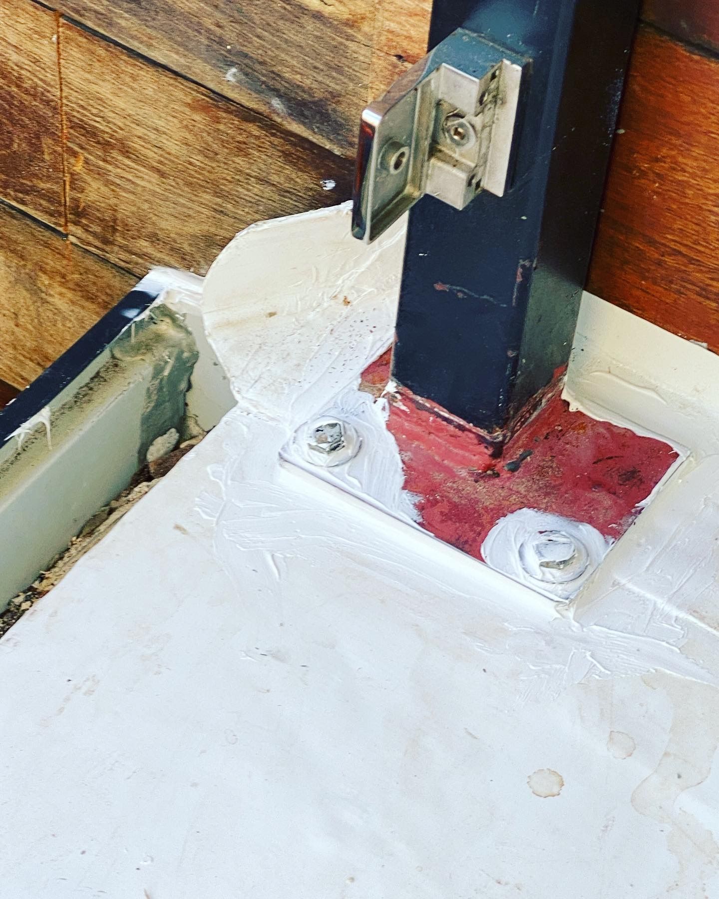 A close up of a metal post on a wooden floor.