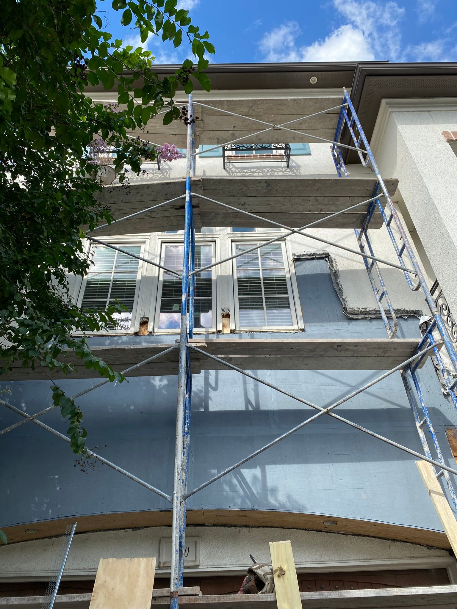 A building with scaffolding on the side of it is being painted.