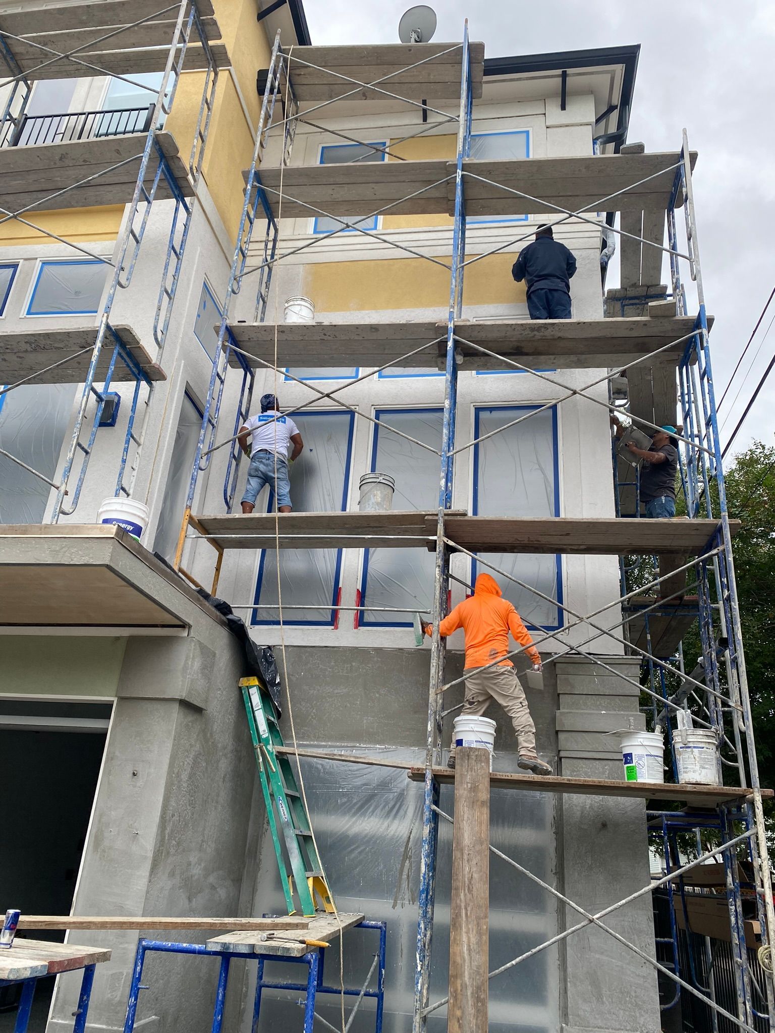 A building is being painted with scaffolding around it
