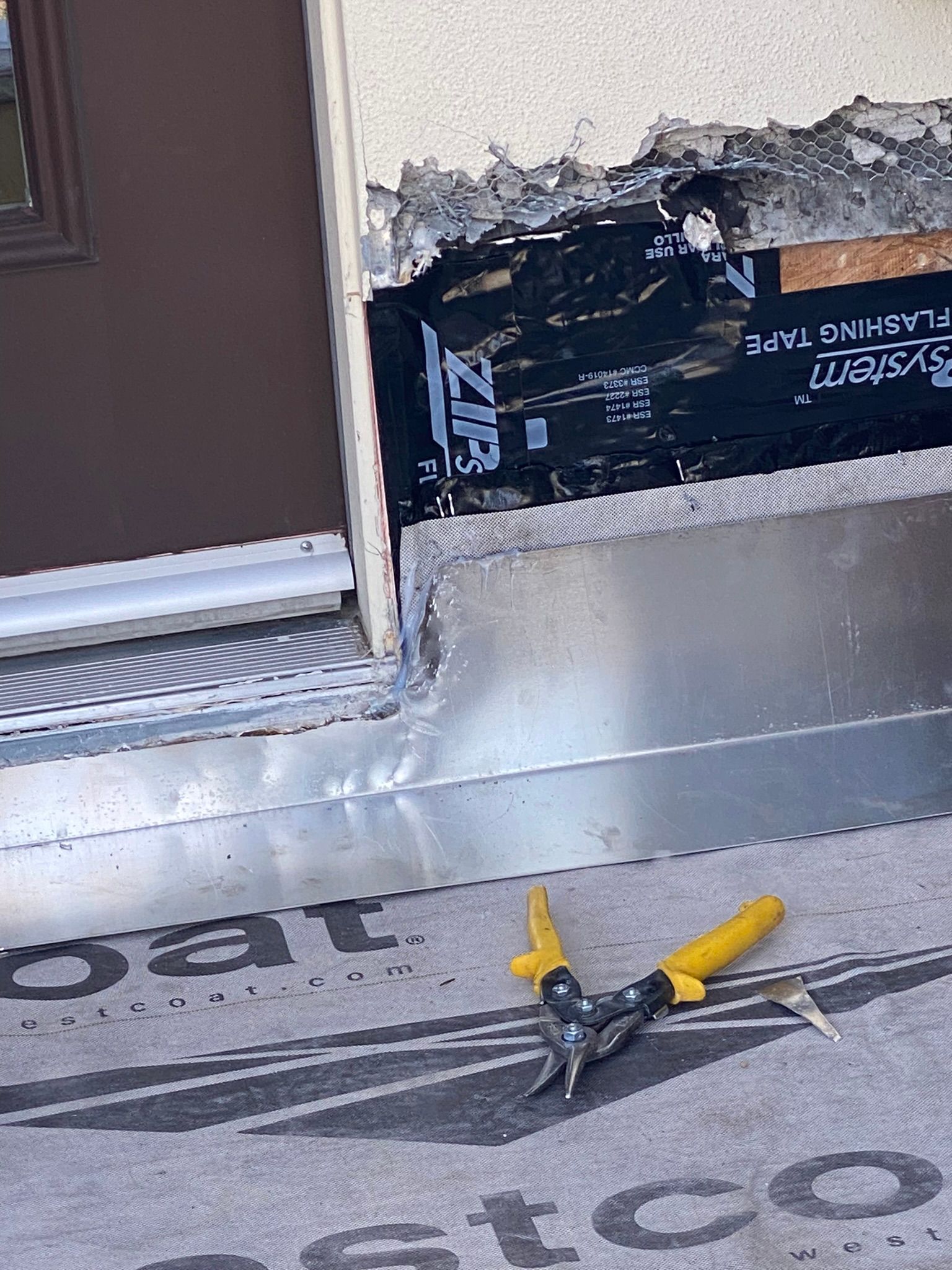 A pair of pliers are sitting on a carpet next to a door.
