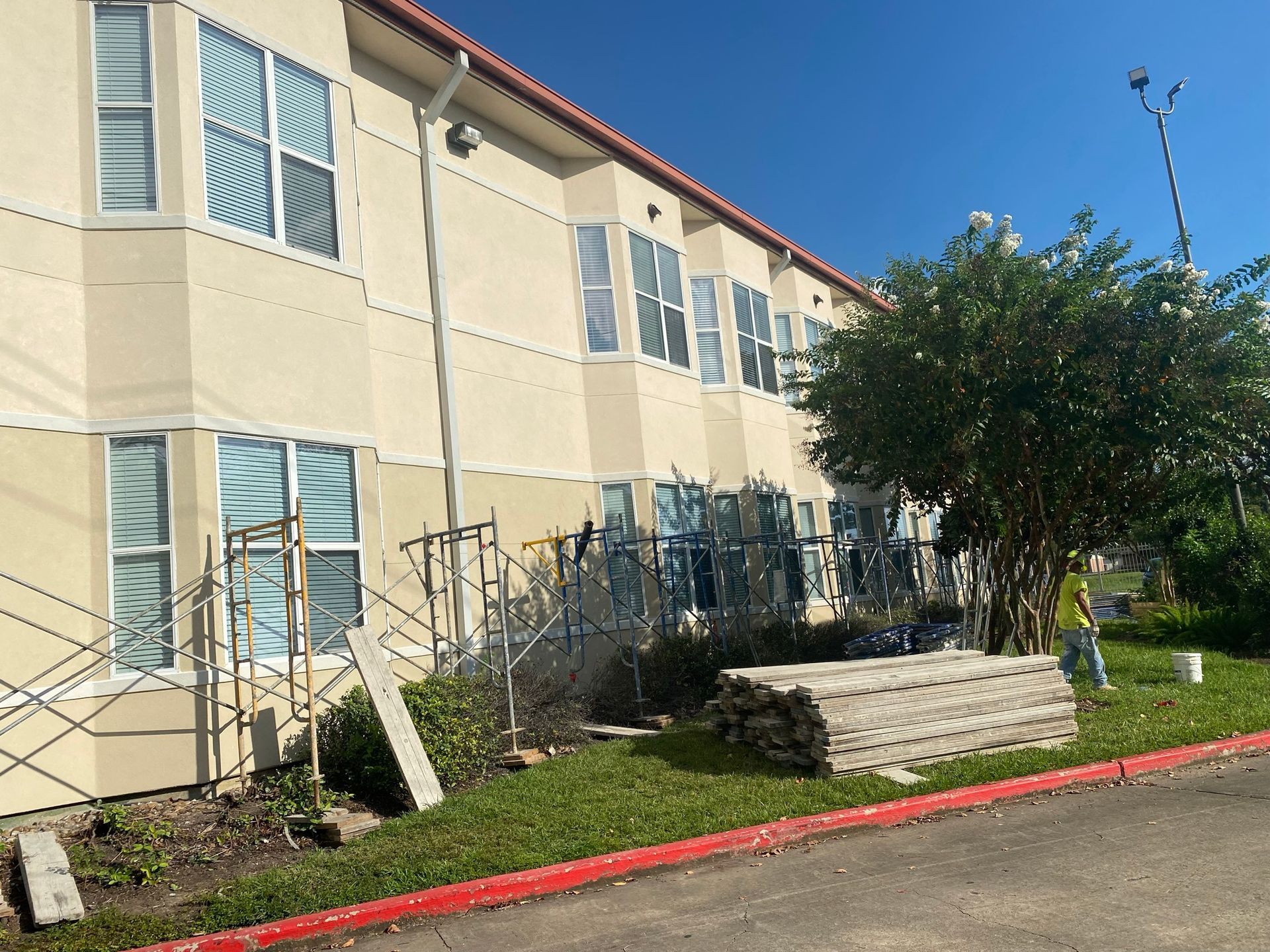 A large building with a lot of windows is being painted.