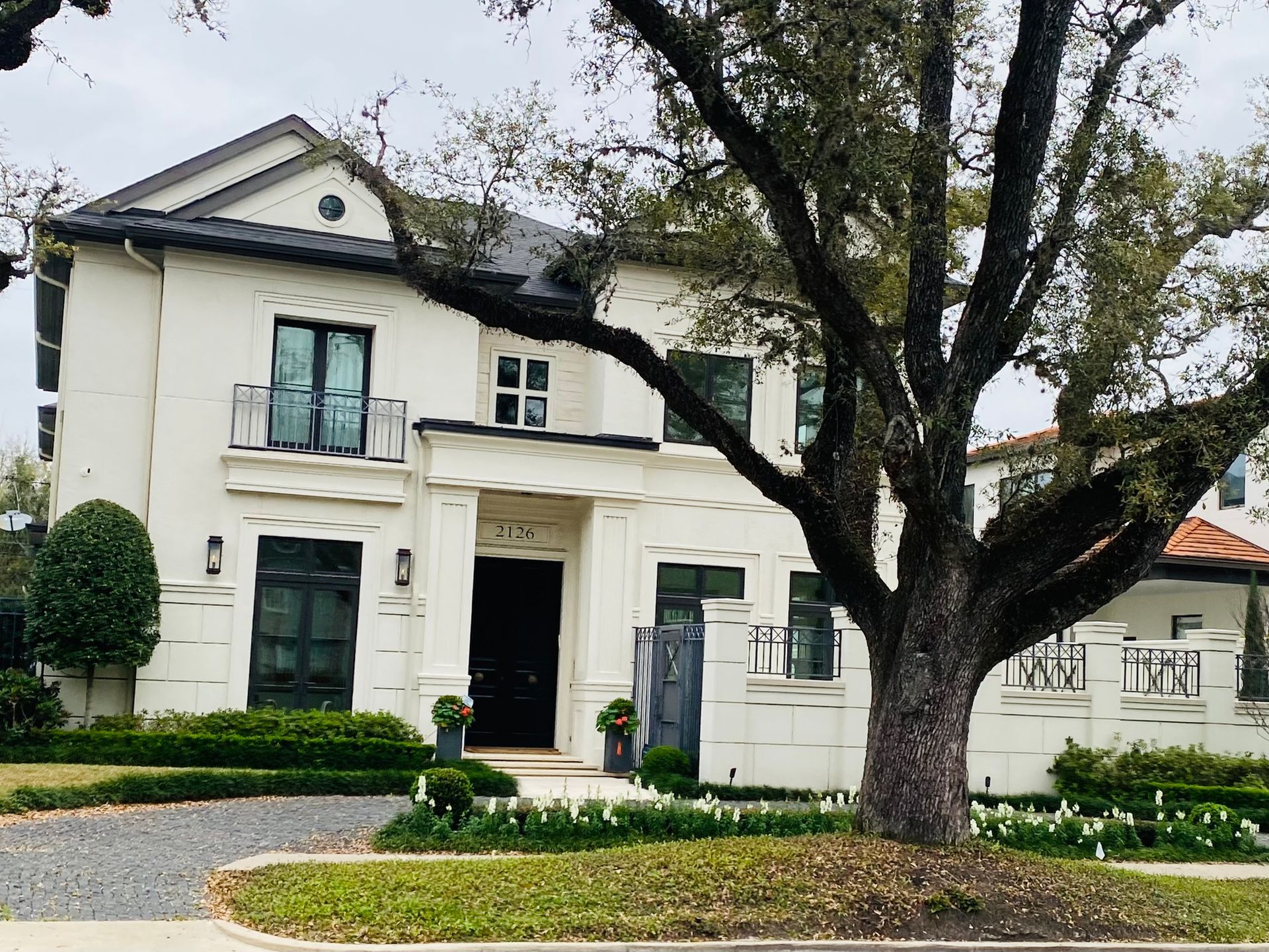 A large white house with a tree in front of it