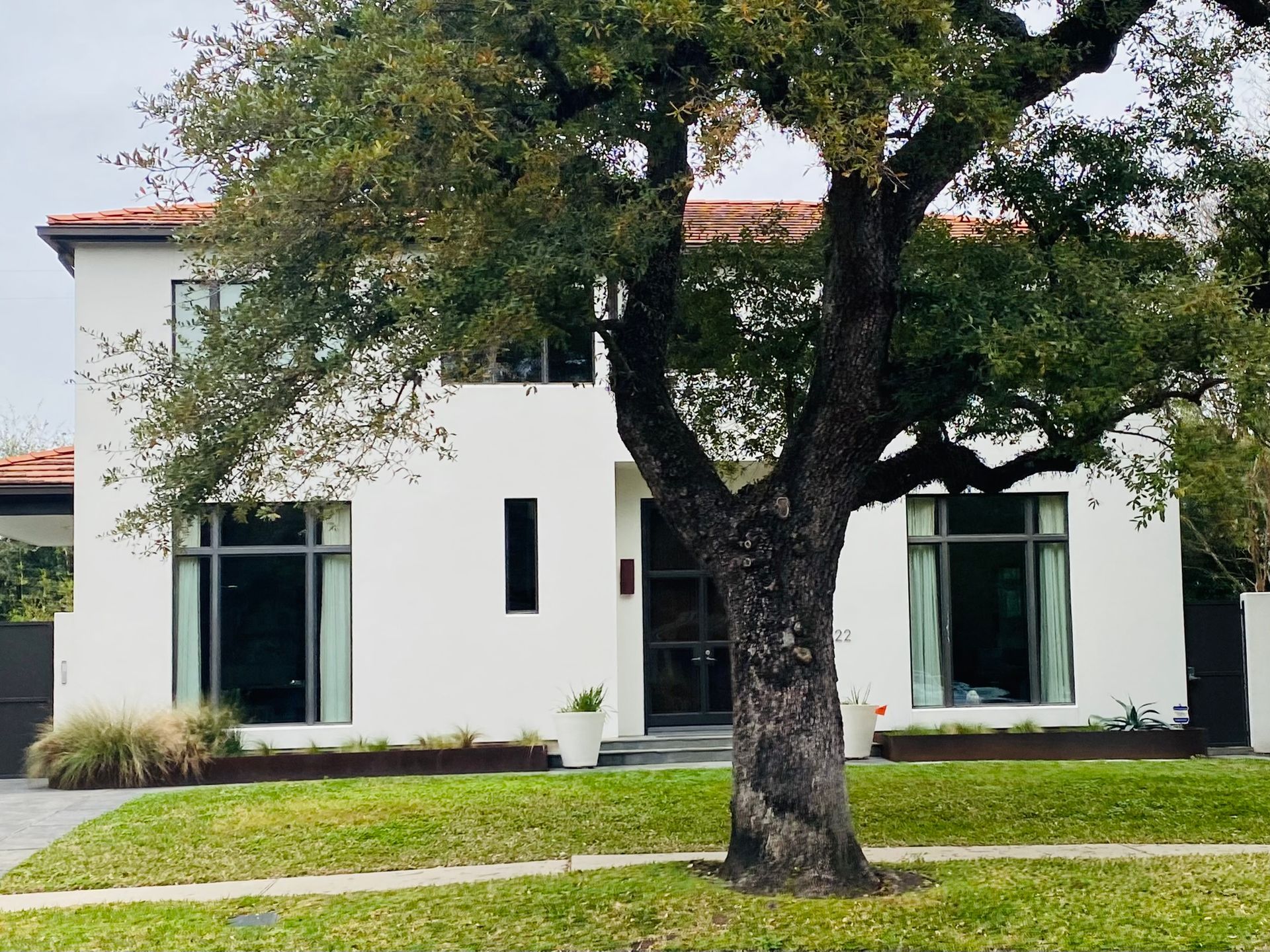 A white house with a tree in front of it