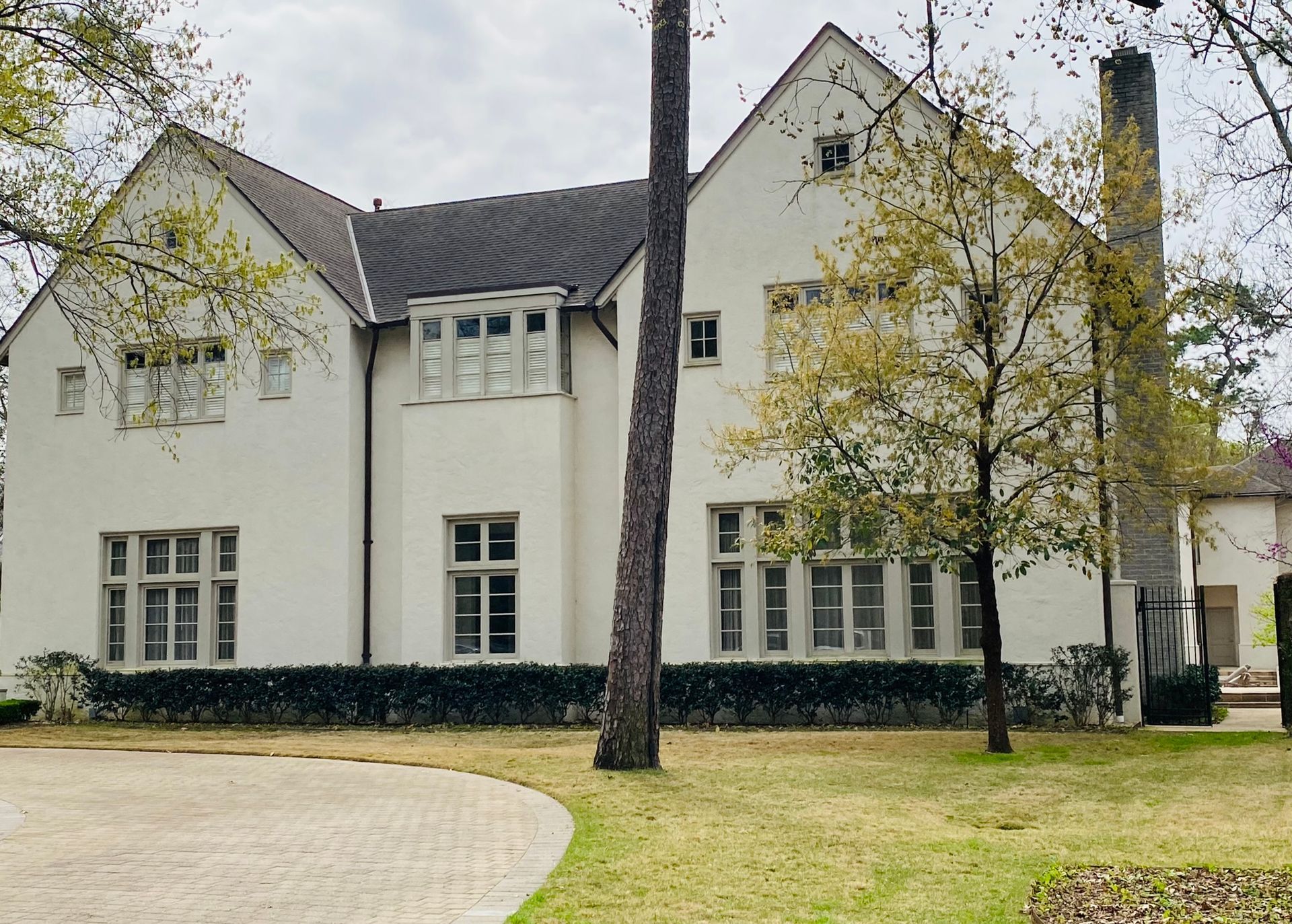 A large white house with a lot of windows and trees in front of it