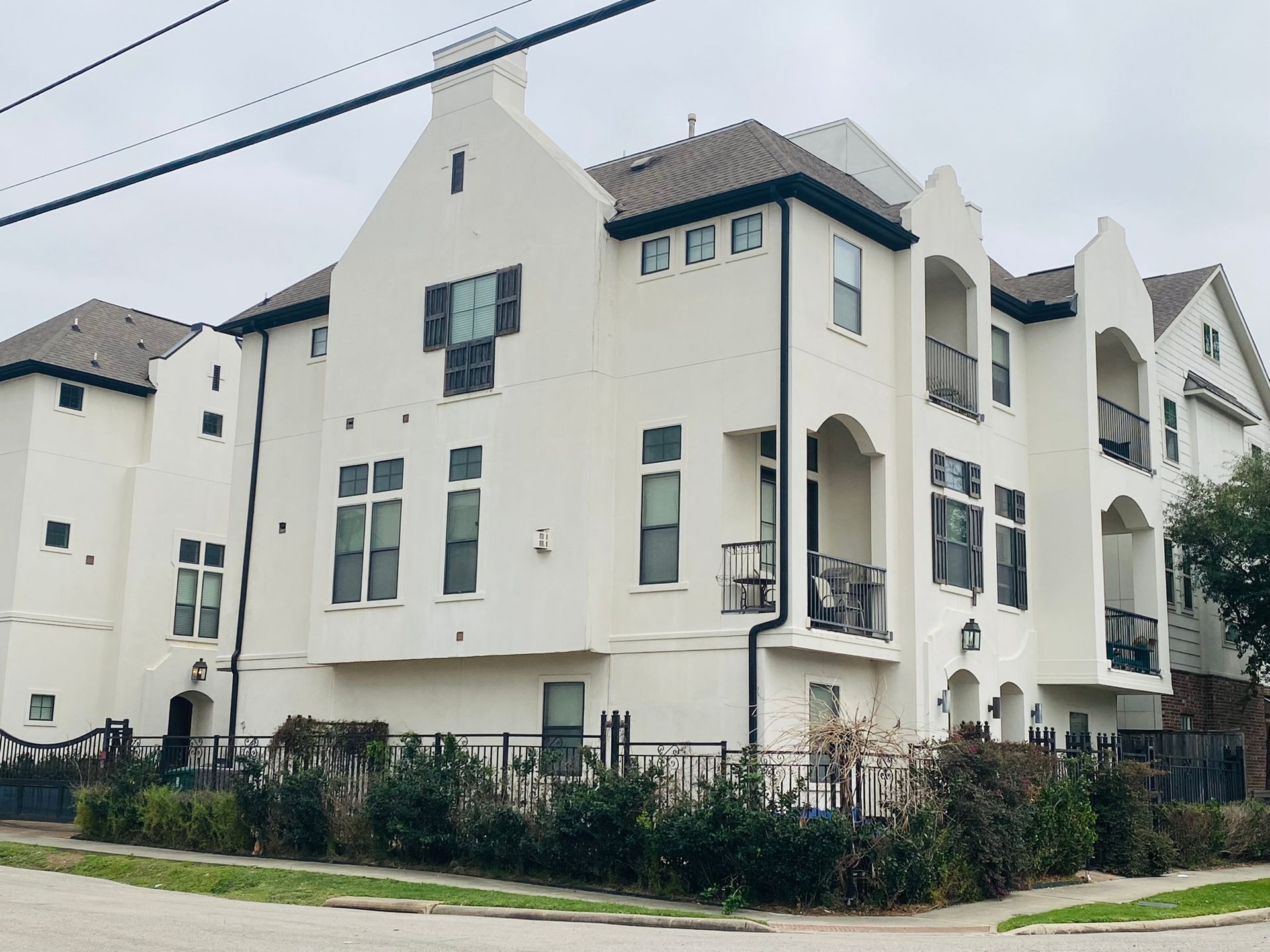 A large white apartment building with a brown roof