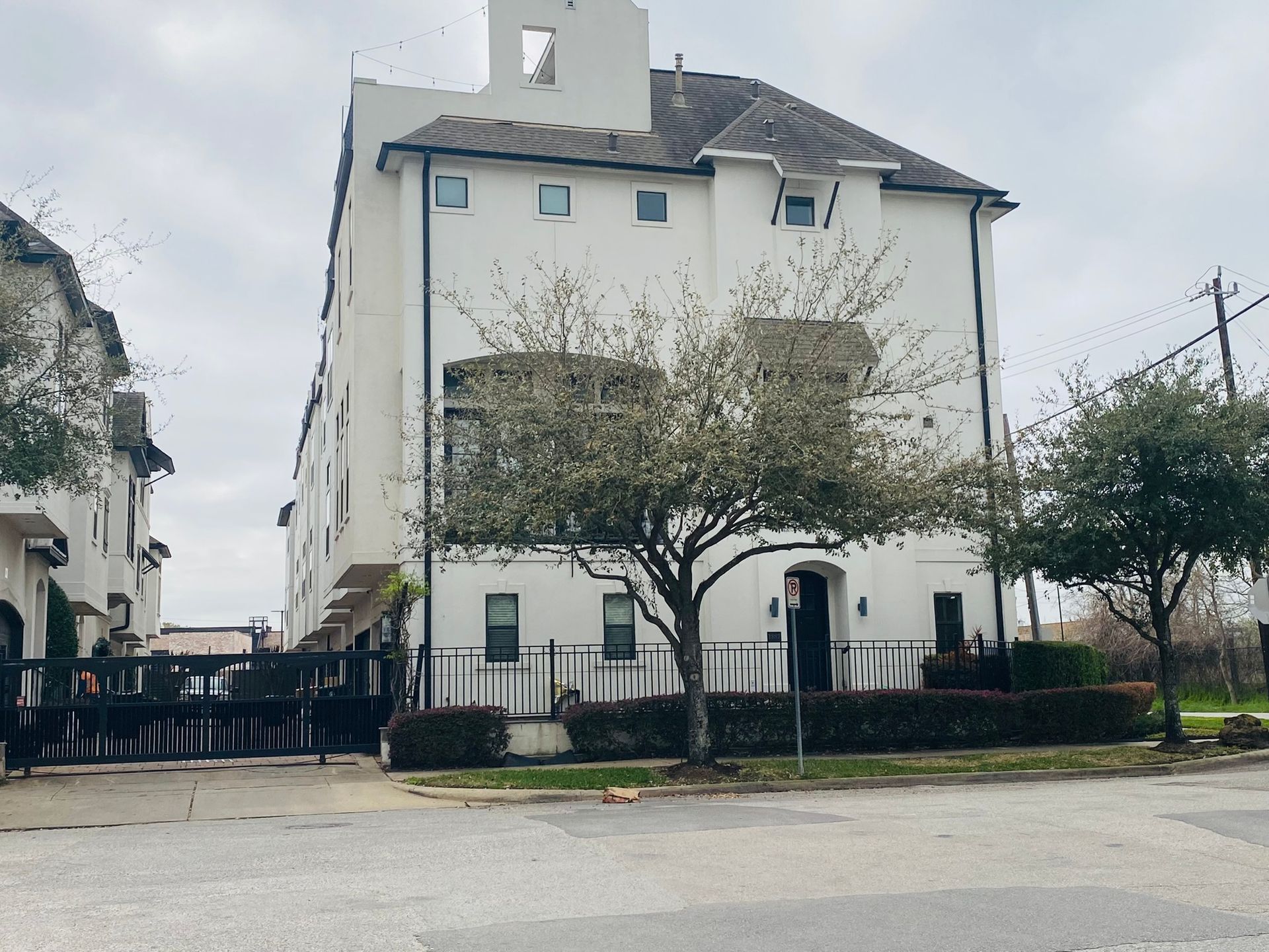 A white building with a tree in front of it