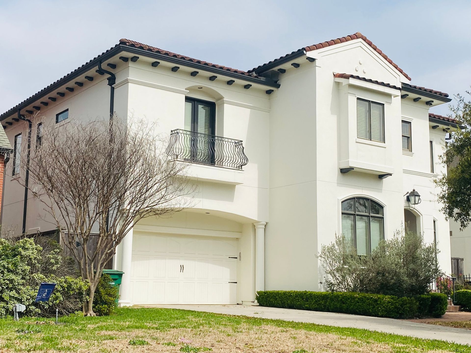 A large white house with a garage and a balcony