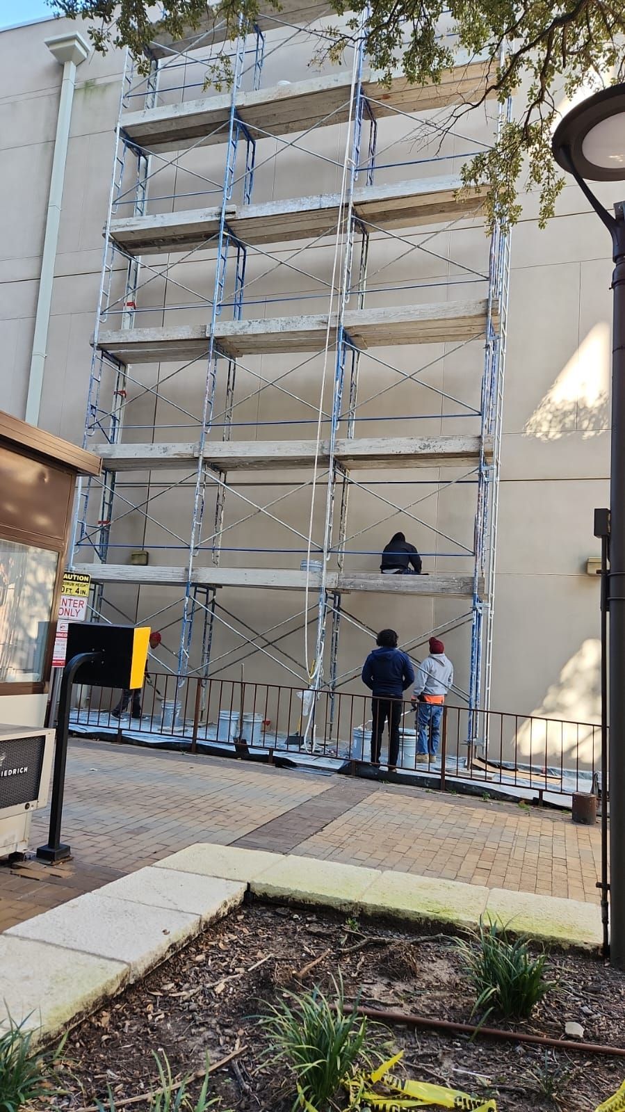 A group of people are standing in front of a building with scaffolding.