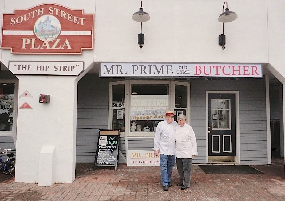 Two men standing in front of a store called mr. prime butcher