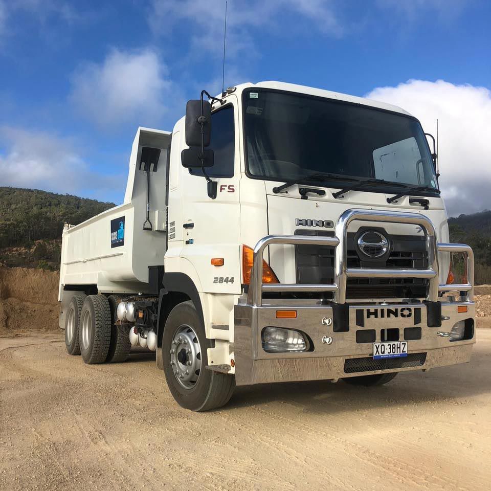 A White Hino Dump Truck is Parked on a Dirt Road — Blue Gum Earthworks in Atherton, QLD