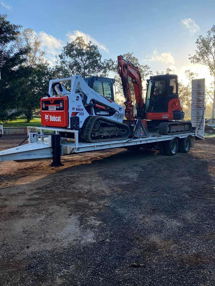 A Bulldozer and an Excavator Are Sitting on Top of a Trailer — Blue Gum Earthworks in Atherton, QLD