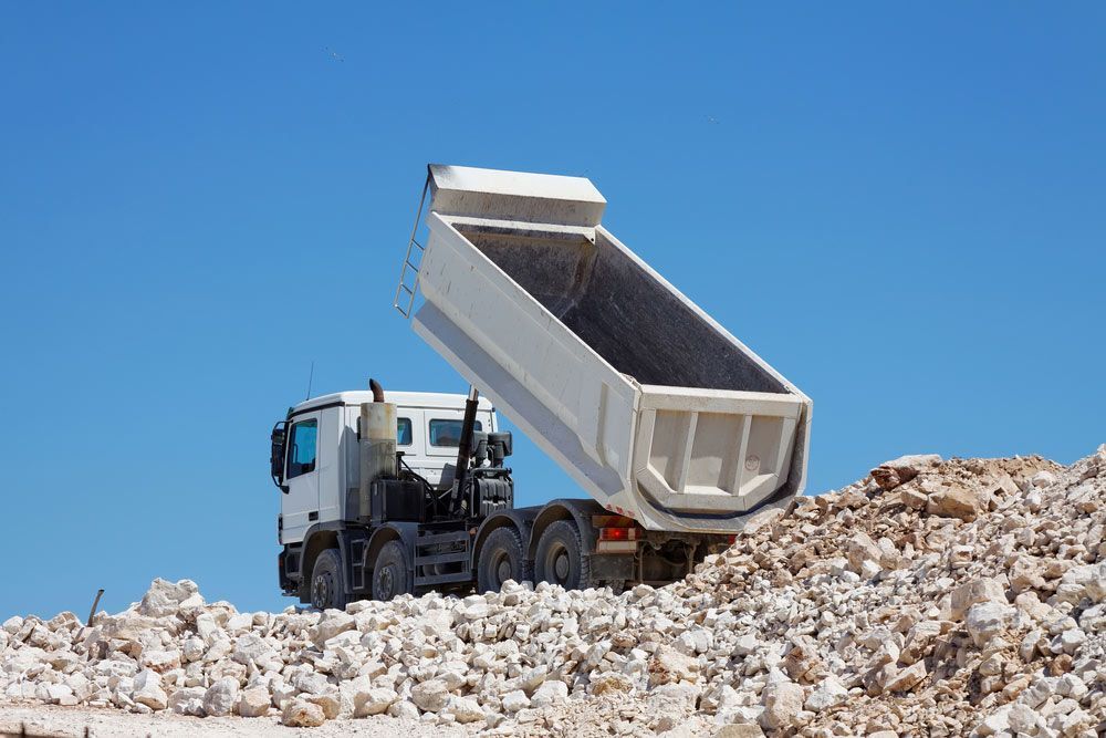 A Dump Truck is Sitting on Top of a Pile of Rocks — Blue Gum Earthworks in Atherton, QLD