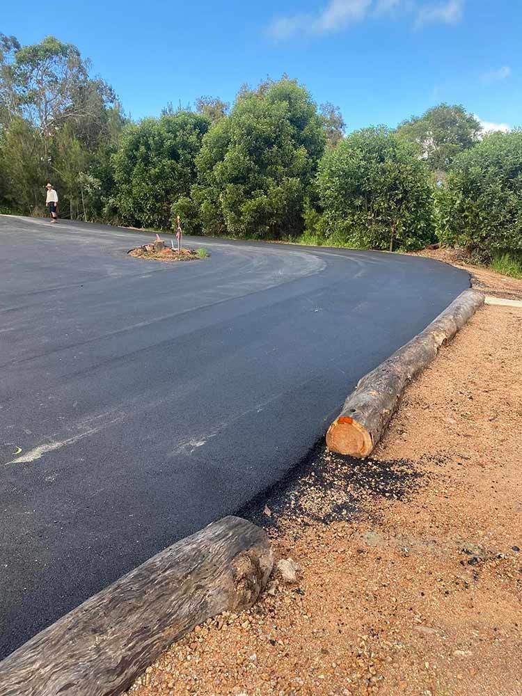A Log is Laying on the Side of a Road — Blue Gum Earthworks in Atherton, QLD