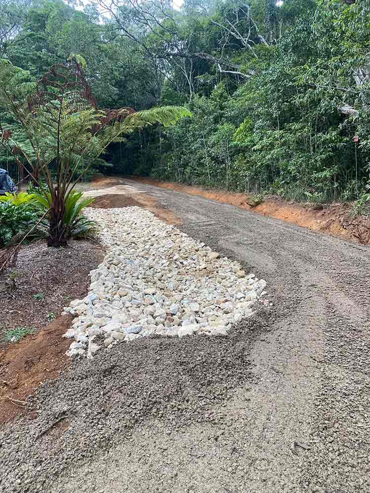 A Dirt Road Surrounded by Trees and Rocks in the Middle of a Forest — Blue Gum Earthworks in Atherton, QLD
