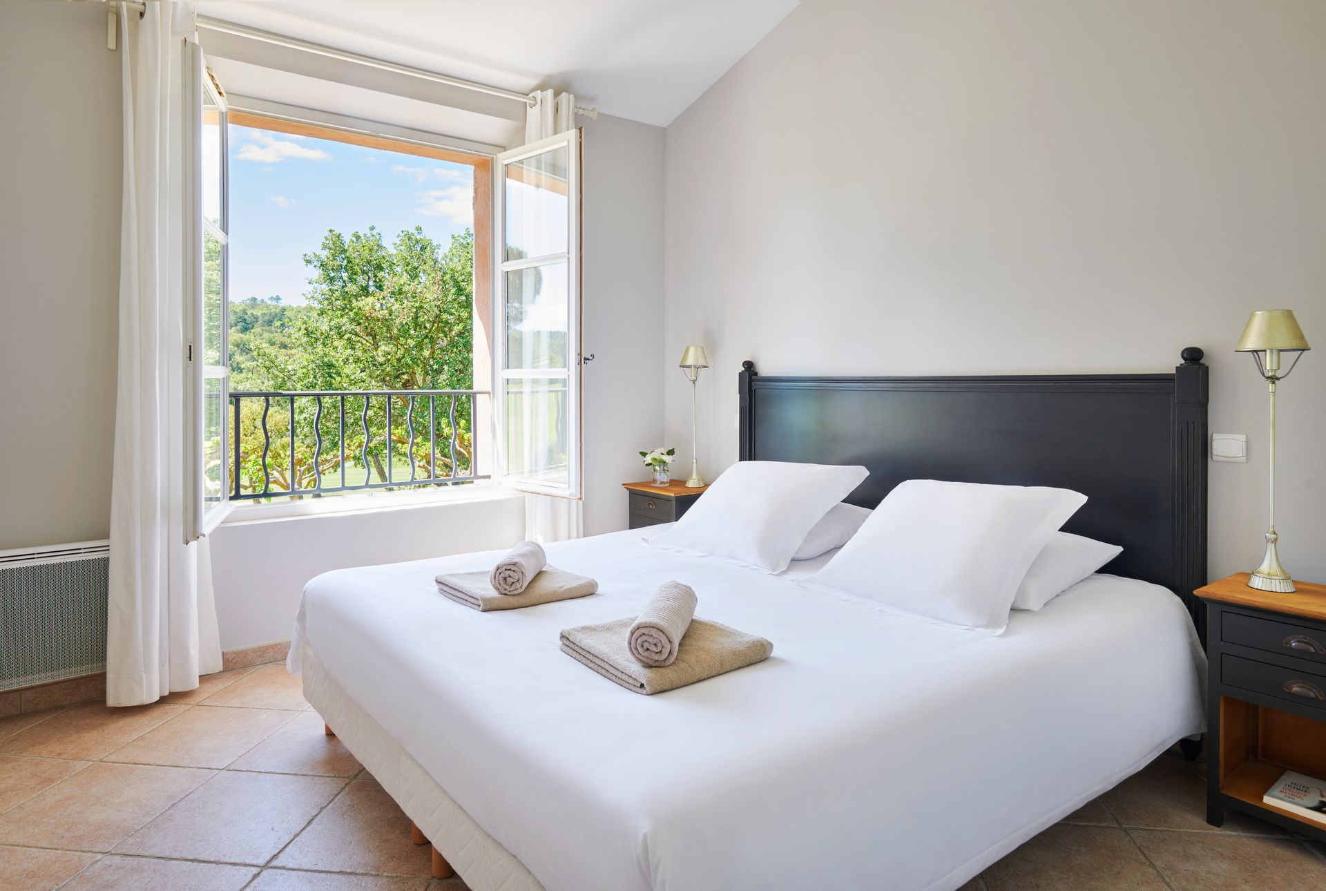 A bedroom with a king size bed and a window.