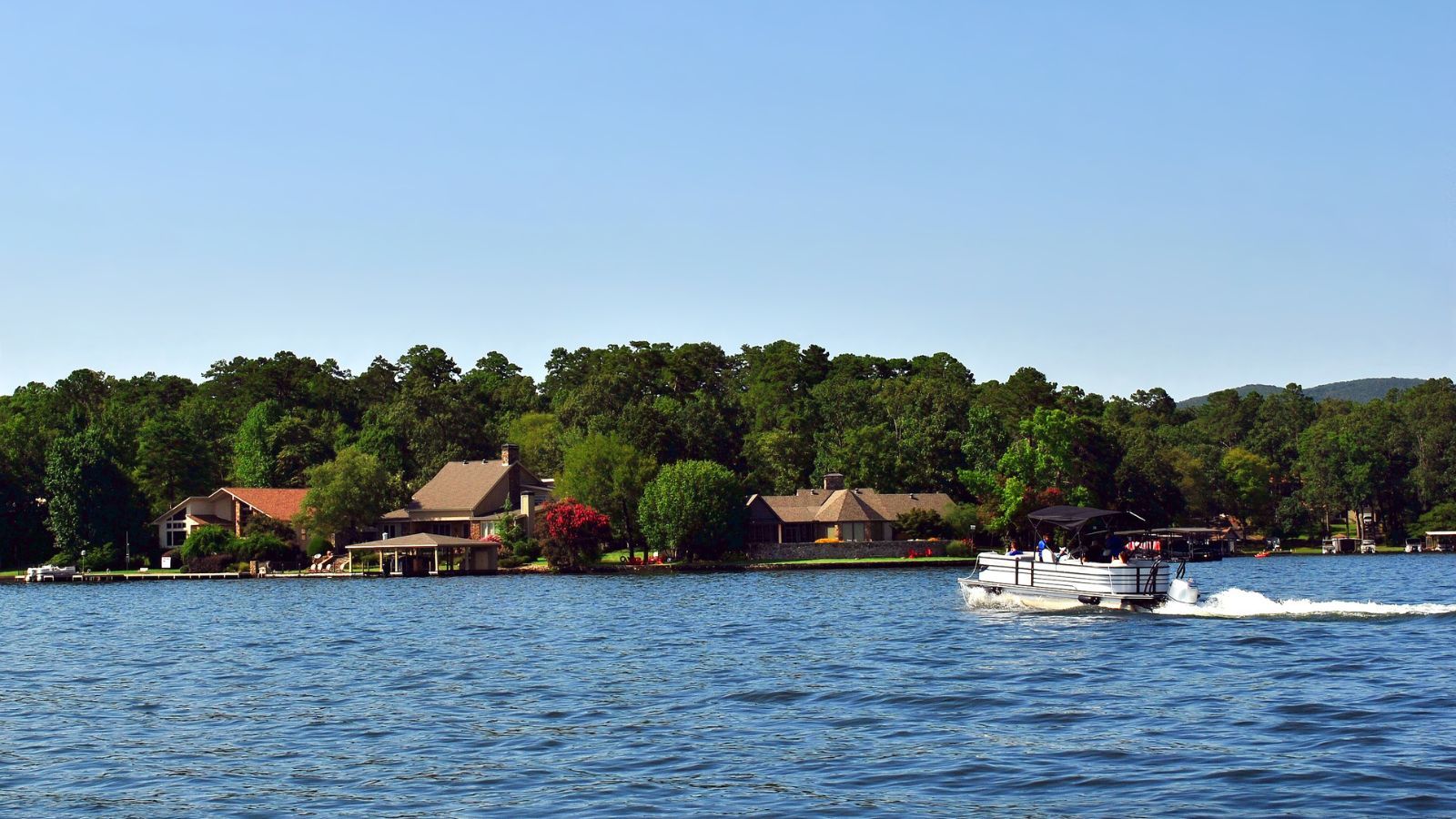 family boating near houses on a beautiful tennessee lake
