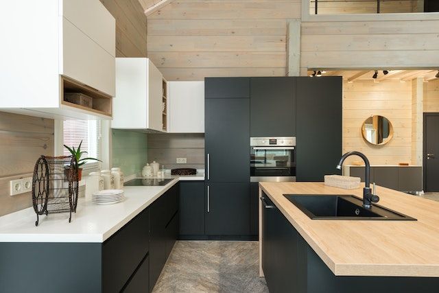a modern kitchen with black cupboards
