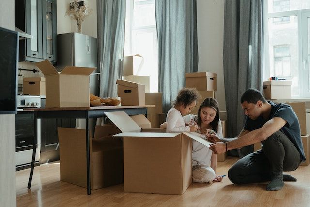 picture-of-two-adults-with-their-kids-surrounded-by-moving-boxes