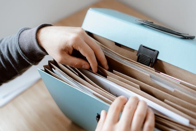 person-looking-through-a-file-folder-for-documents