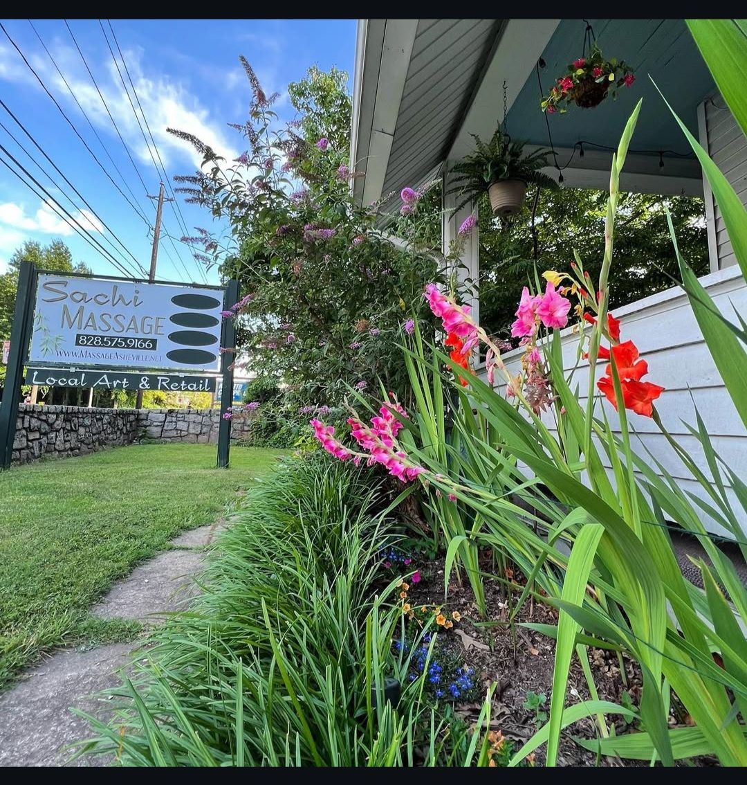 A garden with flowers and a sign that says sunshine massage