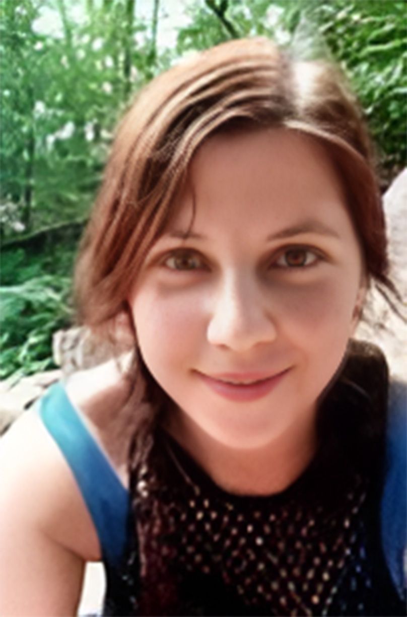 A close up of a woman 's face with trees in the background.