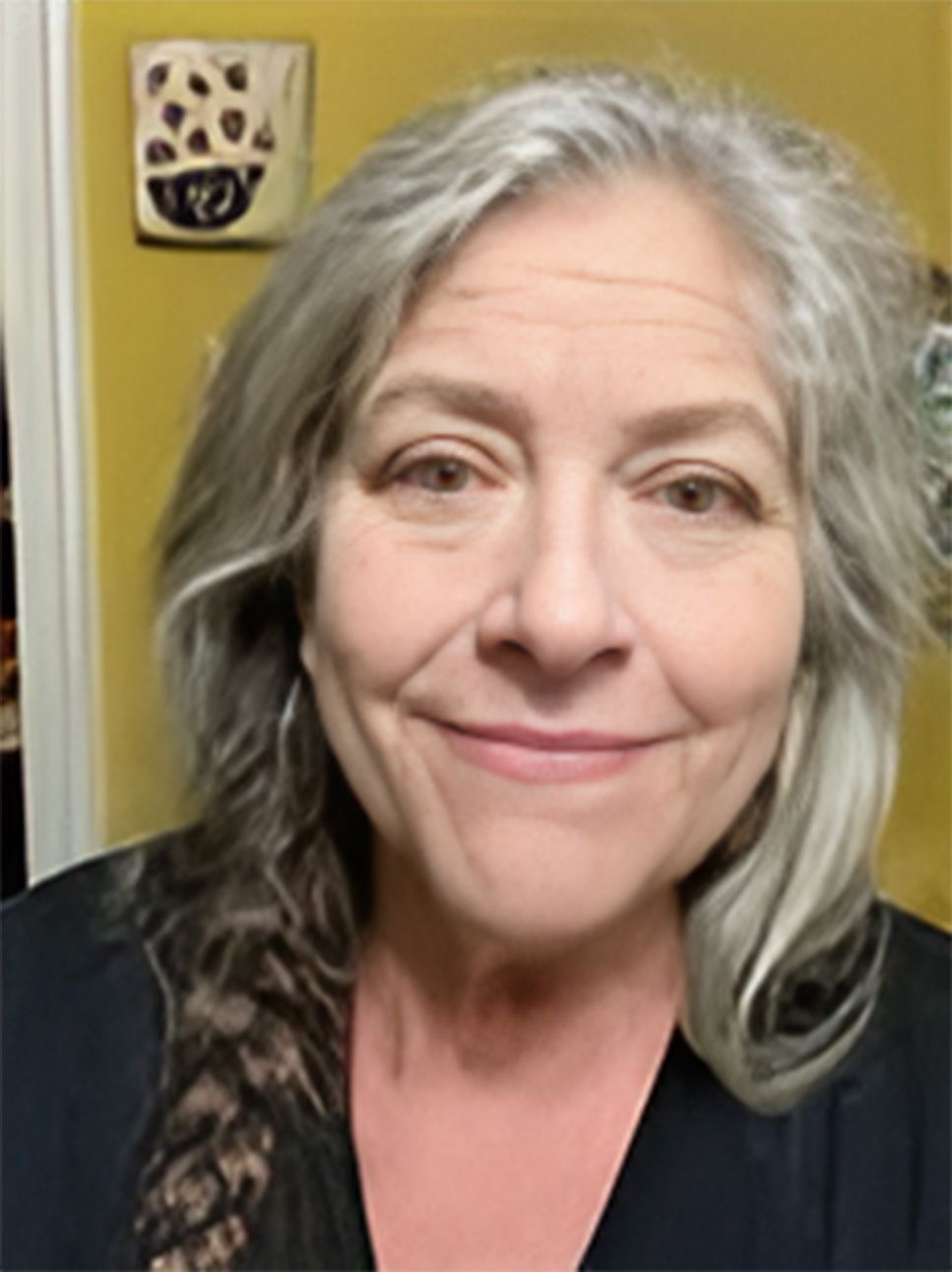 A woman with gray hair is smiling for the camera.