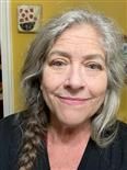 A woman with gray hair is smiling for the camera.